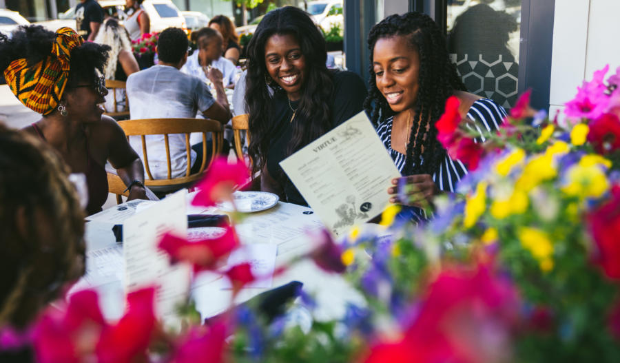 Friends dine on the patio at Virtue in Hyde Park